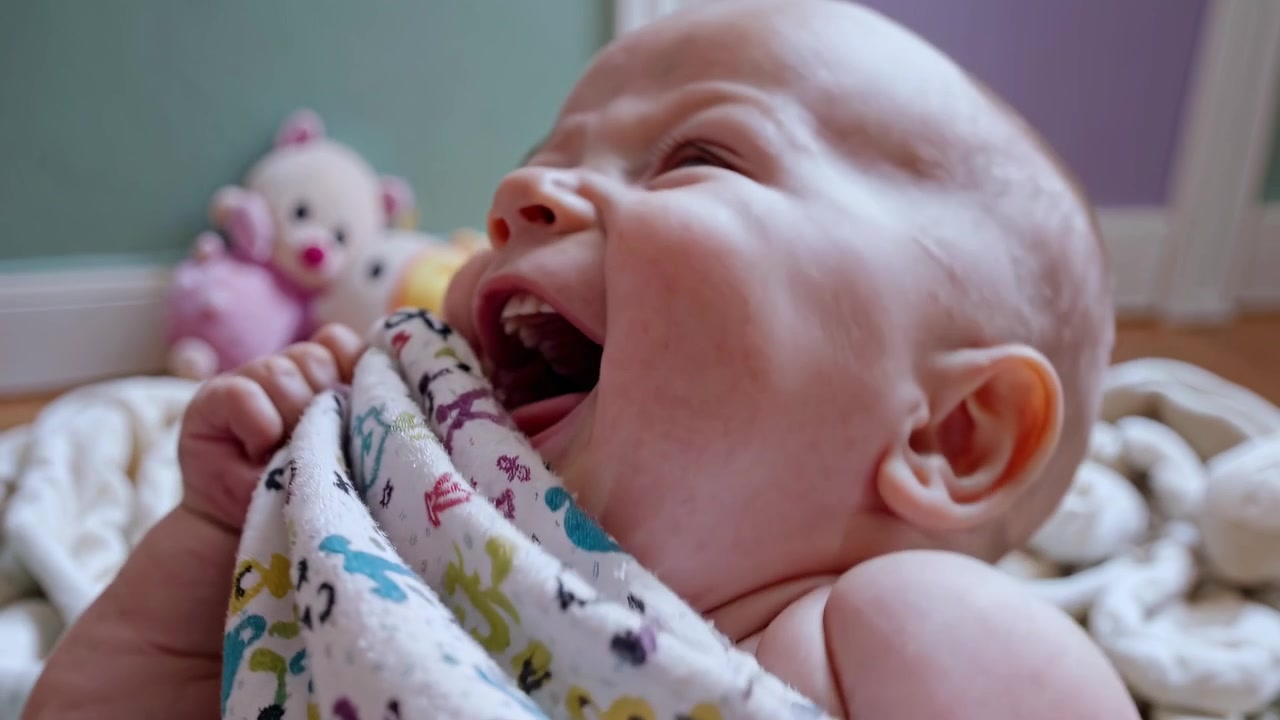 Happy Baby Chewing on a Patterned Blanket