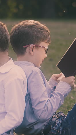 junior student in shirt hides behind book and pushes back to schoolmate sitting in school yard closeup slow motion