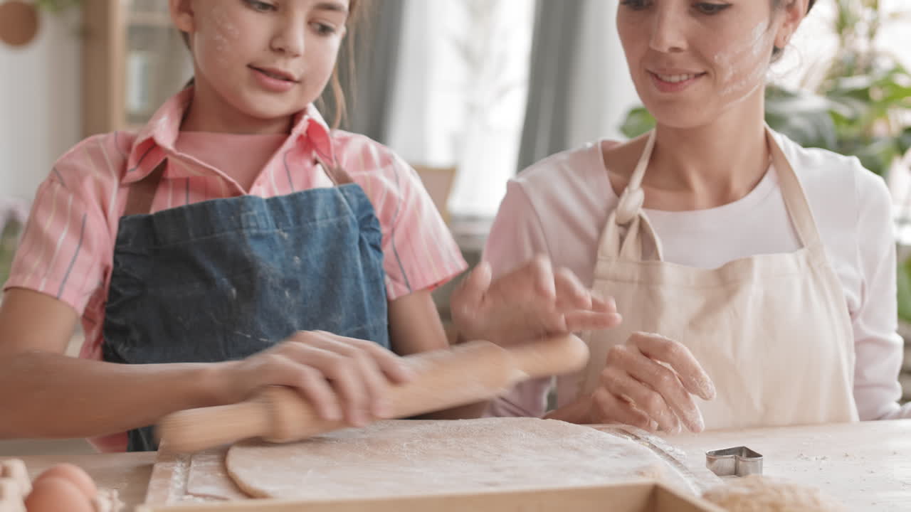 веселая девушка делает печенье со своей мамой