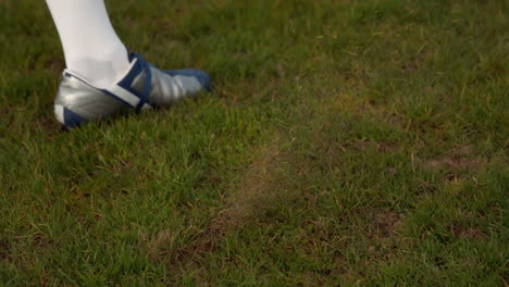 jugador de fútbol pateando la pelota en el campo