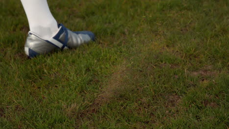 football player kicking the ball on pitch