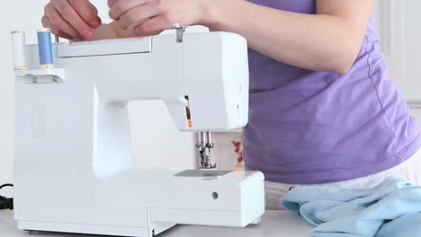 mujer preparando una máquina de coser