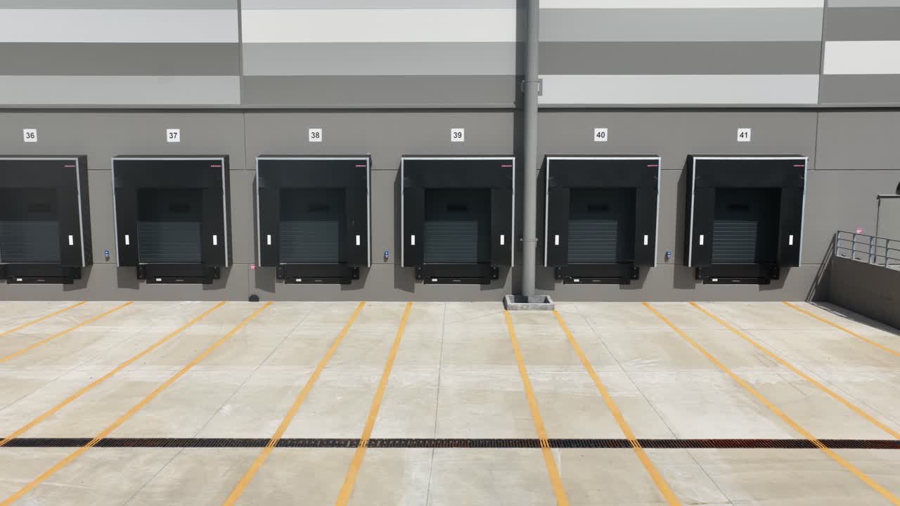 Modern truck loading bay at distribution center. Logistics infrastructure. Commercial shipping. Aerial close up drone video