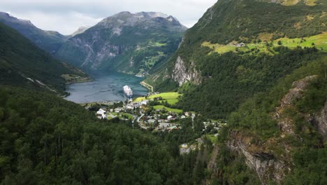 Hermoso-Valle-Verde-En-Una-Cadena-Montañosa-Con-Un-Fiordo-O-Lago-Y-Un-Crucero-En-El-Puerto,-Noruega,-Europa,-Drone