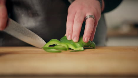 el chef cortando pimienta verde