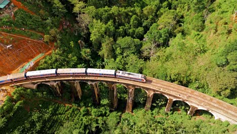 breathtaking aerial drone footage of a train crossing the iconic nine arches bridge in ella, sri lanka.