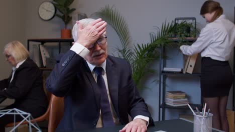 bored senior man boss doing face palm gesture while developing new project on laptop computer