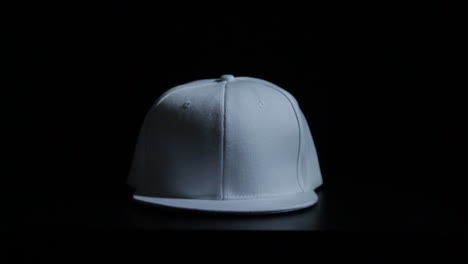 white snapback hat covered in dripping black paint with black infinity background