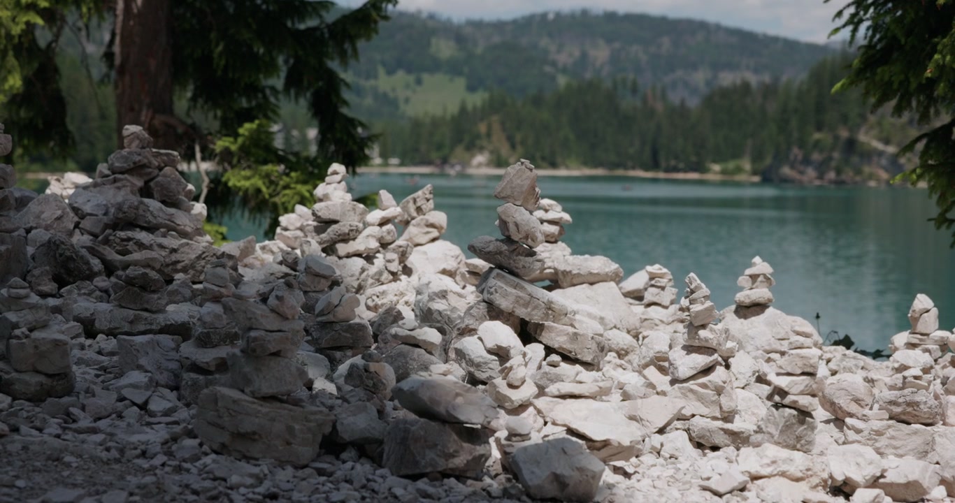 Bunke af hvide sten på den klippefyldte østlige bred af Lago di Braies i Dolomitterne, Sydtyrol, Italien. Statisk billede.