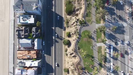 Vista-Panorámica-Del-Tráfico-Que-Circula-Por-La-Playa-De-La-Ciudad,-Filmada-Con-Un-Dron-Panorámico-De-Lado-Mirando-Directamente-Hacia-Abajo