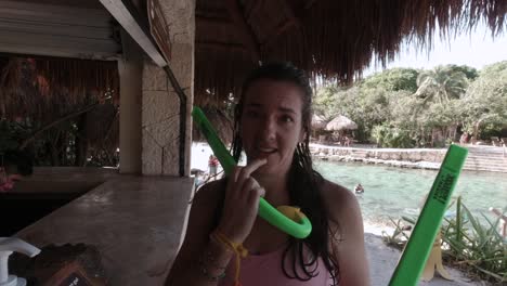 Caucasian-Female-Talking-to-the-Camera-while-Holding-Two-Snorkel-Tubes