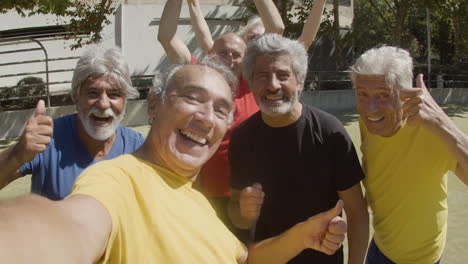 pov de felices jugadores de fútbol senior tomando selfie en el campo de fútbol