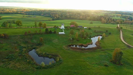 Traditional-white-windmill-in-the-autumn-colored-nature-during-a-sunset