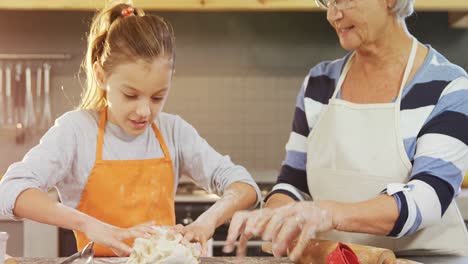 Happy-grandmother-and-child-kneading-dough-for-cookies-4K-4k