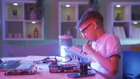 un niño pequeño estudiando electrónica. repara partes de computadoras.