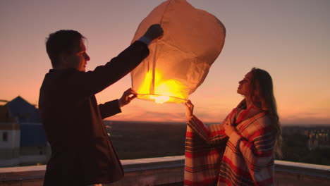 para lanzar una linterna del cielo por la noche en el techo. los amantes están juntos. linternas del cielo chinas.