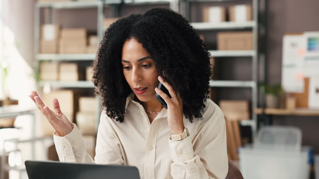 Stressed Businesswoman Talking on Phone While Working on Laptop