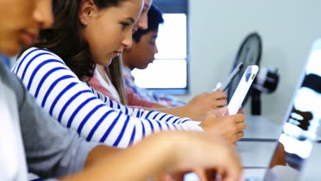 students using digital tablet and laptop in classroom