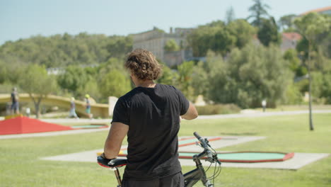 vista trasera de un deportista saludando a sus amigos durante el entrenamiento al aire libre