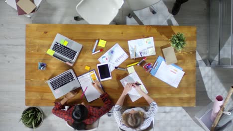 Draufsicht-Auf-Ein-Treffen-Von-Arbeitern,-Die-An-Einem-Tisch-In-Einem-Büro-Sitzen