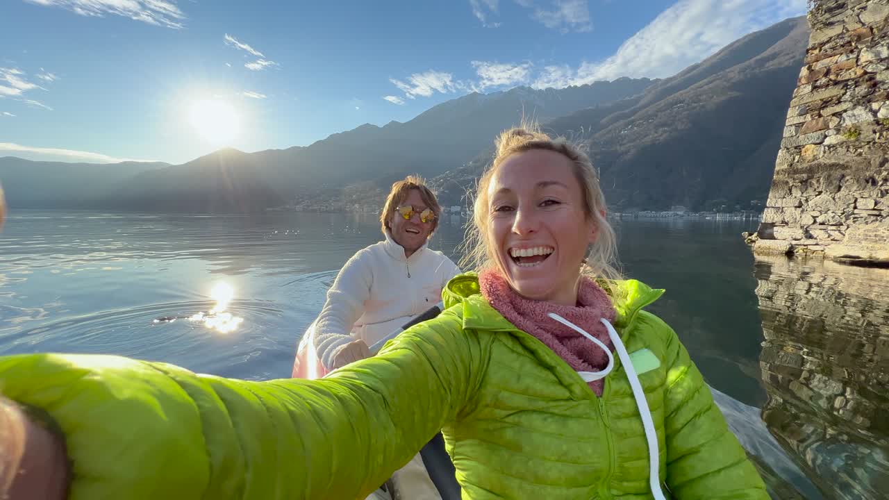 una pareja joven en canoa en un hermoso lago tomando selfies.
