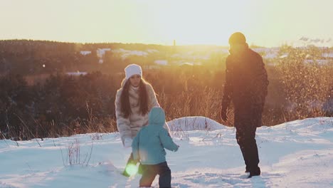 man woman and child in winter clothes throw white snow