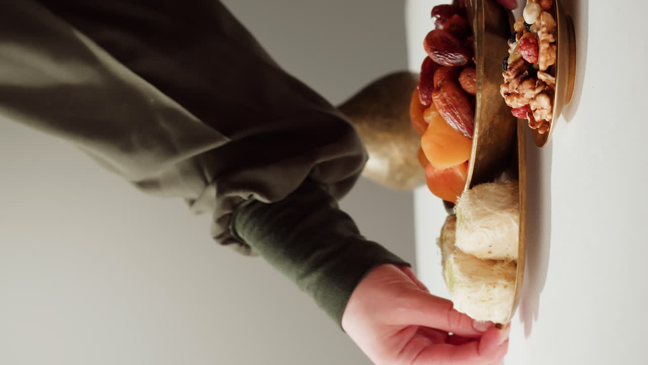 Woman serving traditional Middle Eastern sweets and nuts