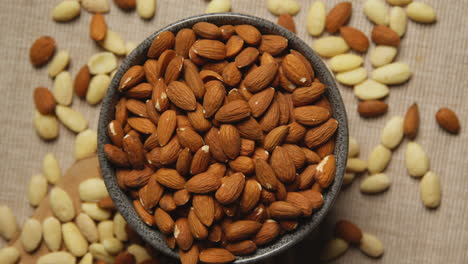 close up overhead shot looking down into bowl containing almond nuts revolving