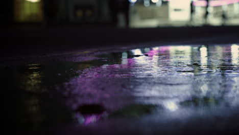 el reflejo de la noria en el charco. personas desconocidas corriendo por el centro de la ciudad.