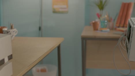 person setting up or installing two beige printers on a wooden desk