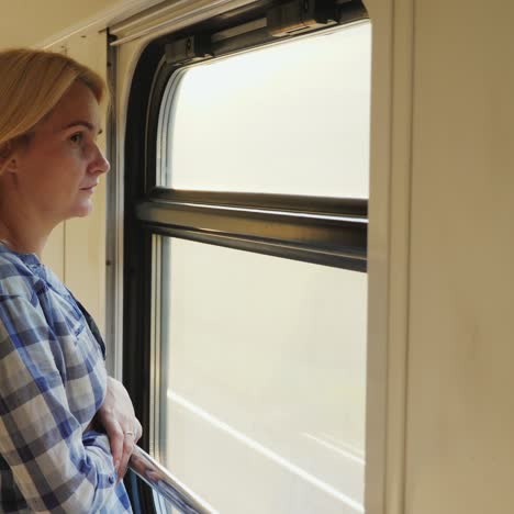 a young woman looks out of the train window