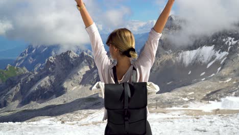 young girl happy to stand in front of spectacular mountain panoroama