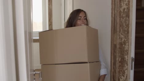 mujer joven poniendo dos cajas en otra