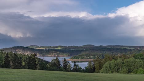 Scenic Lake Landscape with Forested Hills and Cloudy Sky