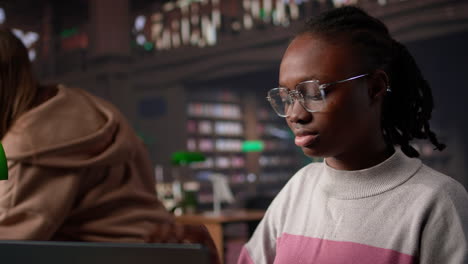 vertical video black girl studying in university library for her bachelor degree diploma