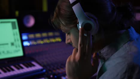 Male-sound-engineer-working-at-a-mixing-desk