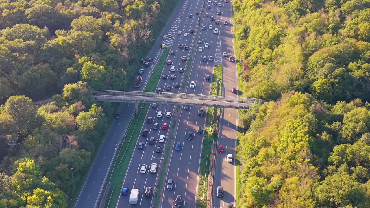Aerial drone over the Waterworks Roundabout, A406 London. A police car blocks an exit, while a slip road accident involving a pickup and four cars causes congestion, delays, and rubbernecking traffic