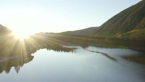 4k aerial drone footage of a sunrise over a lake in the rocky mountains of colorado in the autumn or fall with changing aspen trees