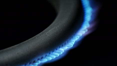 quemador de gas en el horno de primer plano en un fondo negro. video crudo macro 4k.
