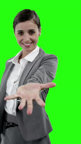 mujer de negocios haciendo gestos contra la pantalla verde