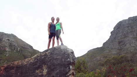 una pareja feliz de pie en una roca