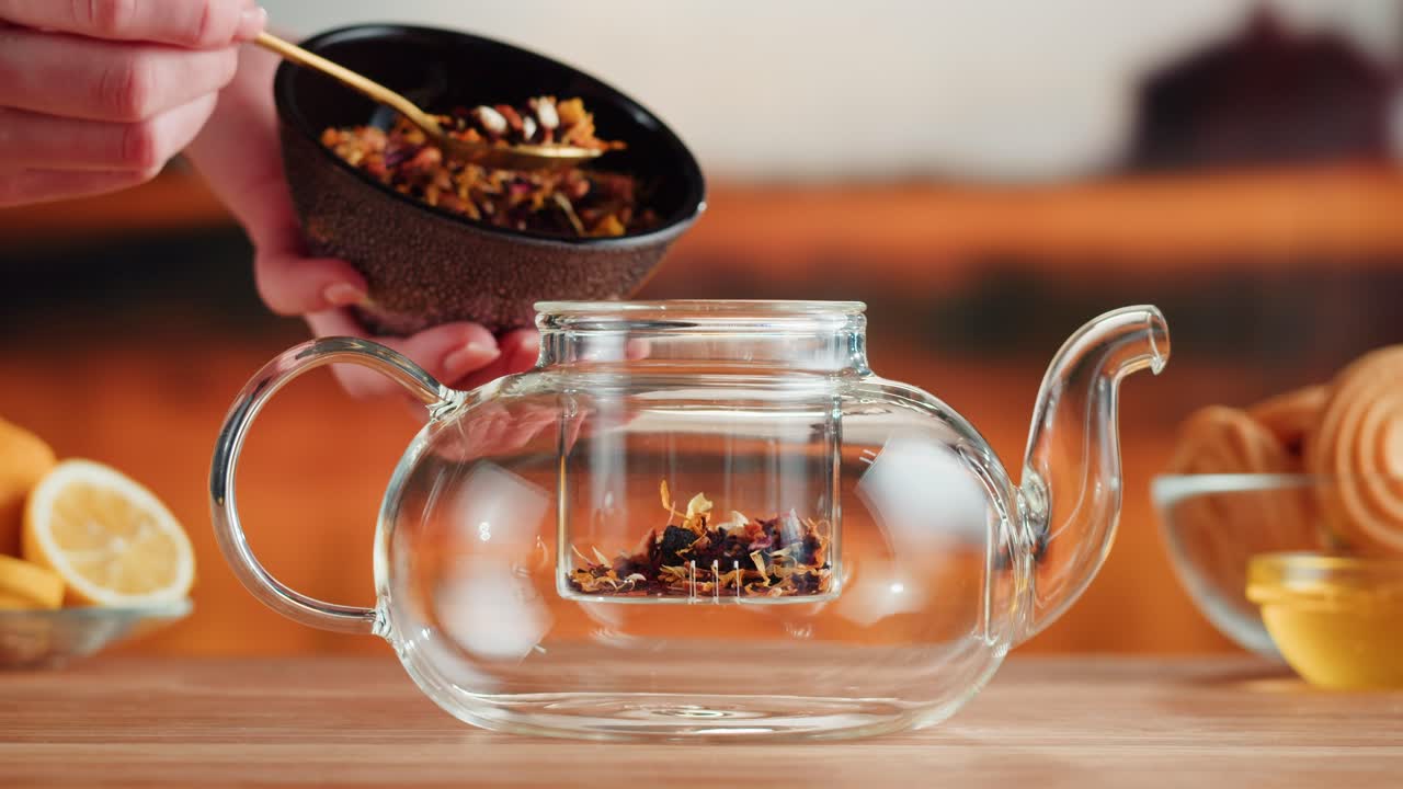 Preparing Herbal Tea in a Clear Glass Teapot