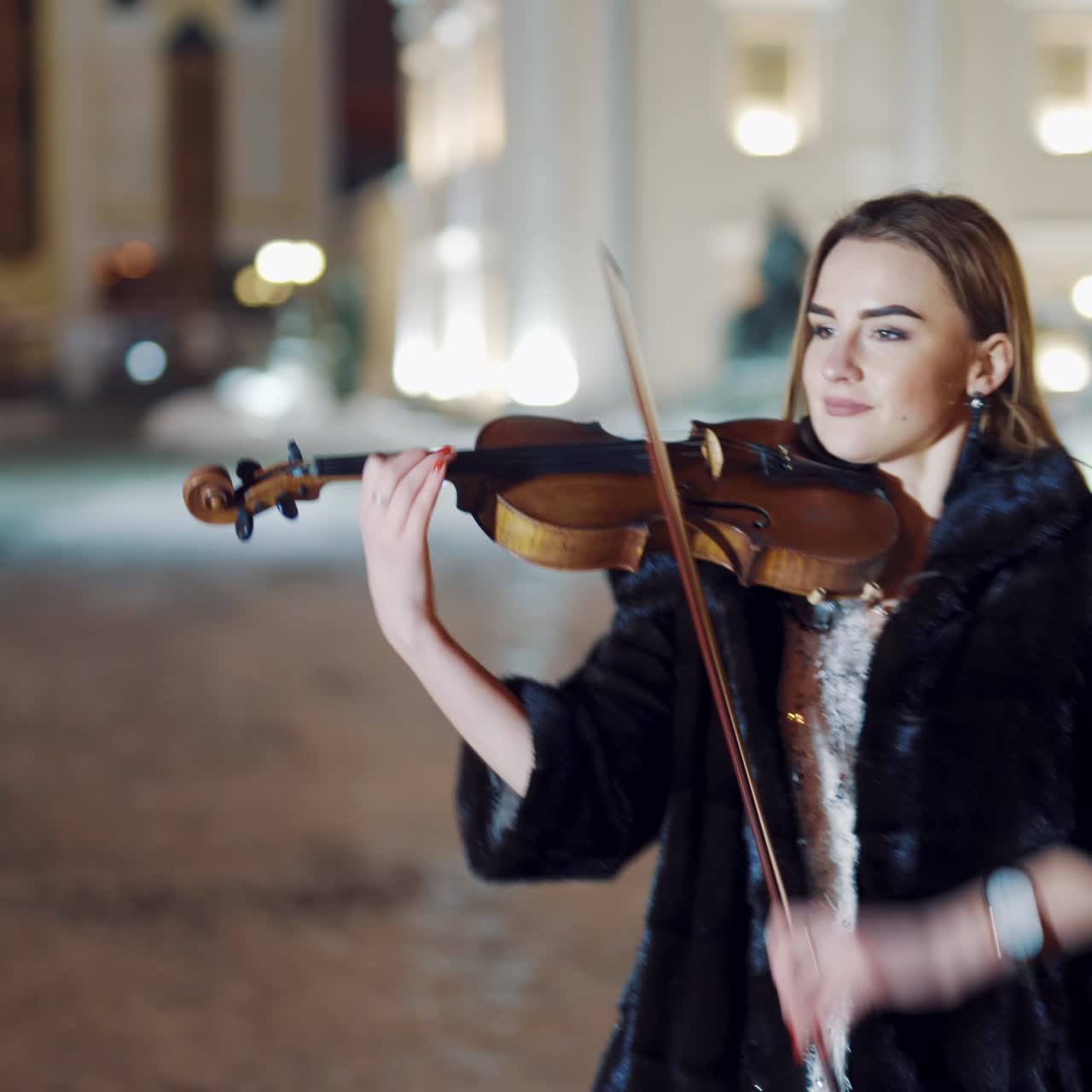 Young lady playing the violin on the street