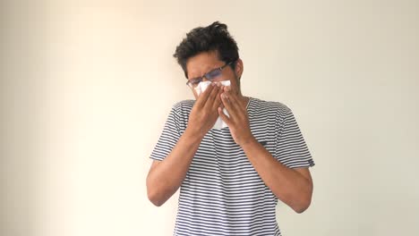 man sneezing into tissue