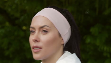 close up of woman wearing headband exercising keeping fit running in countryside or park