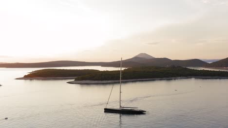 beautiful modern sailboat yacht in mediterranean sea islands at sunset, aerial