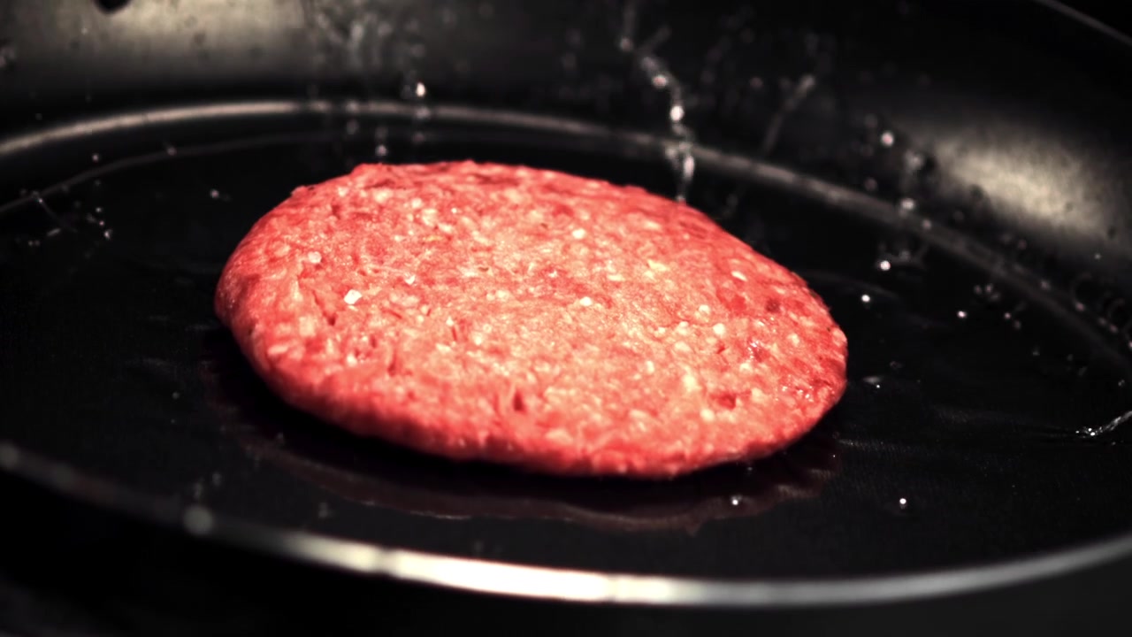 Raw Hamburger Patty Dropping into Hot Frying Pan