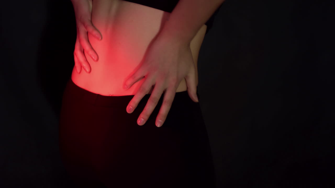 Mal di schiena e concetto di dolore alla colonna vertebrale. Donna che tocca e massaggia la schiena mentre soffre di crampi muscolari