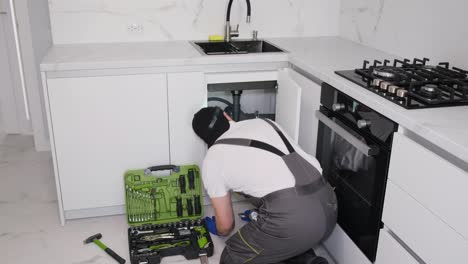 water is flowing under the sink in the kitchen water is flowing under the sink in the kitchen plumber in special clothes at work video
