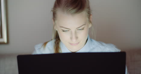 mujer sonriente que trabaja en la computadora portátil en la oficina en casa empresaria escribiendo en el teclado de la computadora 2